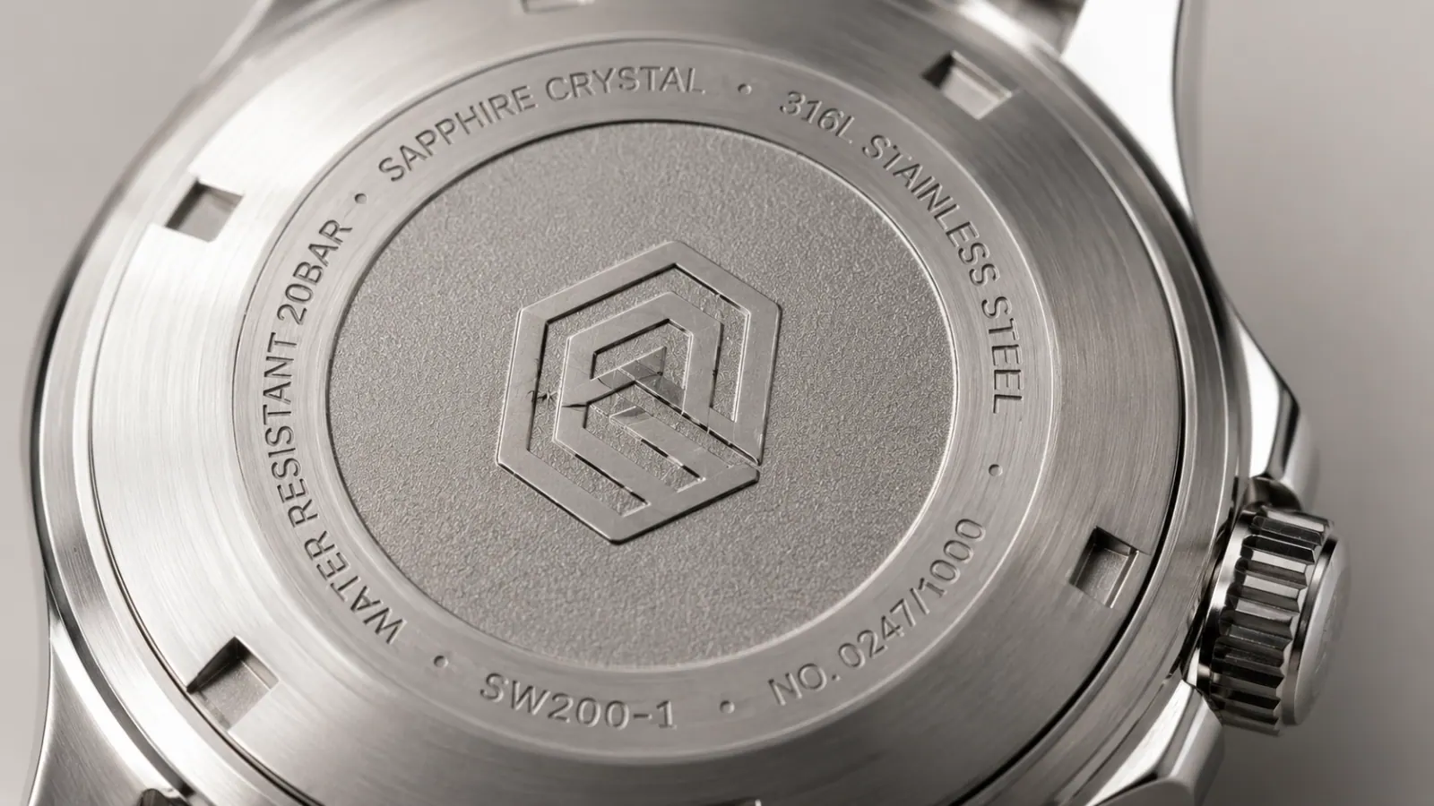 Laser-engraved watch caseback showing logo, serial number, and material marks